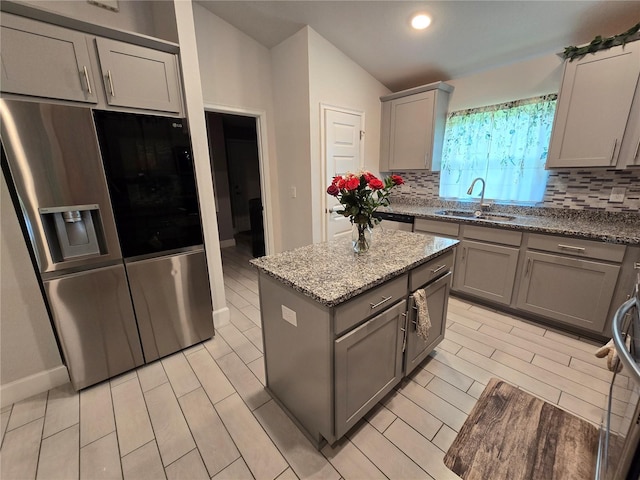 kitchen featuring sink, gray cabinetry, tasteful backsplash, a center island, and stainless steel appliances