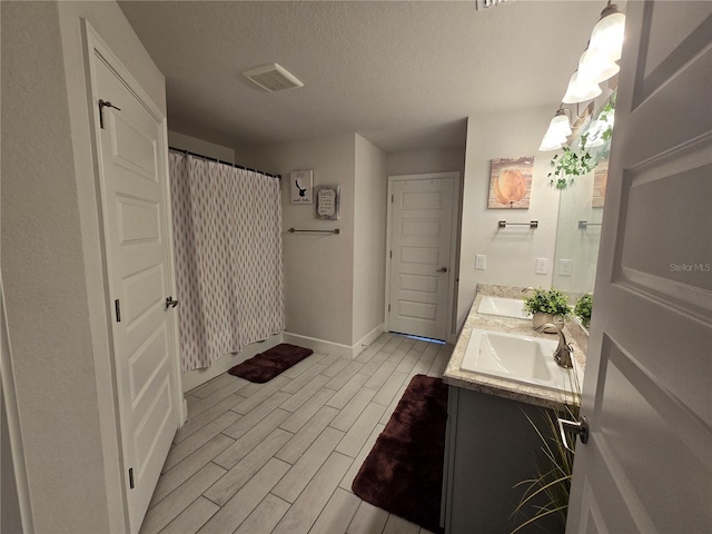 bathroom featuring vanity, curtained shower, hardwood / wood-style floors, and a textured ceiling