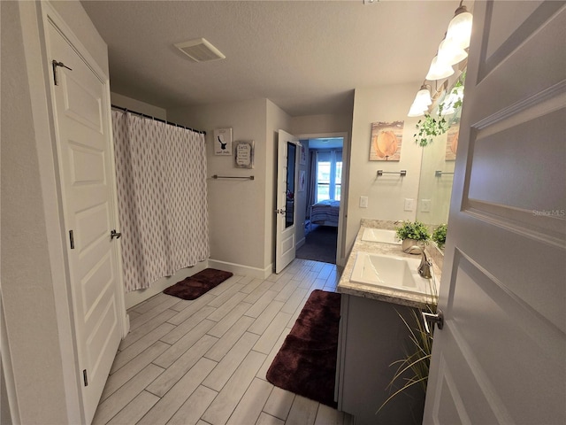 bathroom with hardwood / wood-style flooring, vanity, a shower with shower curtain, and a textured ceiling