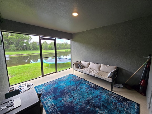 sunroom featuring a water view