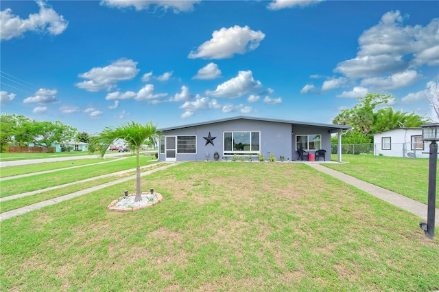 ranch-style house featuring a front lawn and a carport