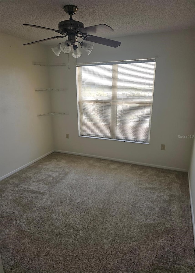 empty room featuring a textured ceiling, ceiling fan, and carpet floors