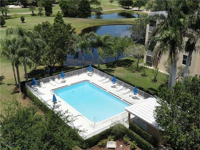 view of swimming pool with a lawn and a water view