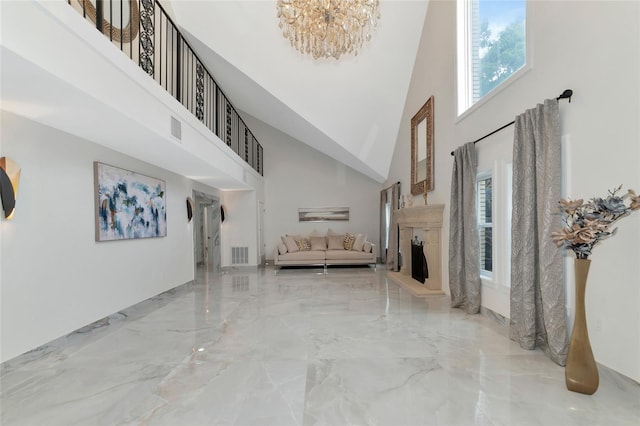 interior space featuring a healthy amount of sunlight, a chandelier, and a high ceiling