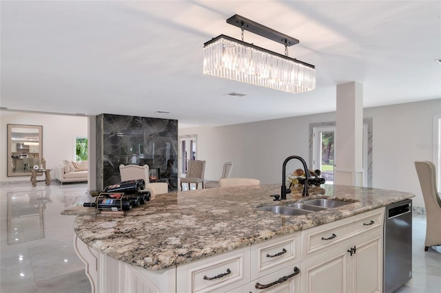 kitchen featuring a high end fireplace, white cabinetry, stainless steel dishwasher, and sink