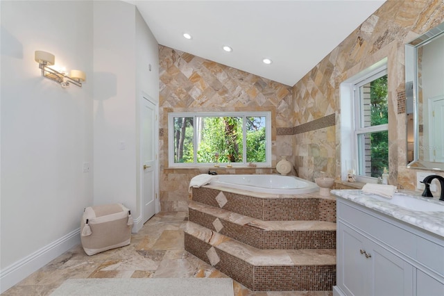 bathroom featuring vanity, tile walls, and tiled tub