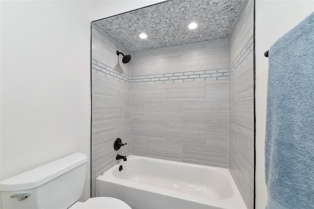 bathroom featuring tiled shower / bath combo and toilet