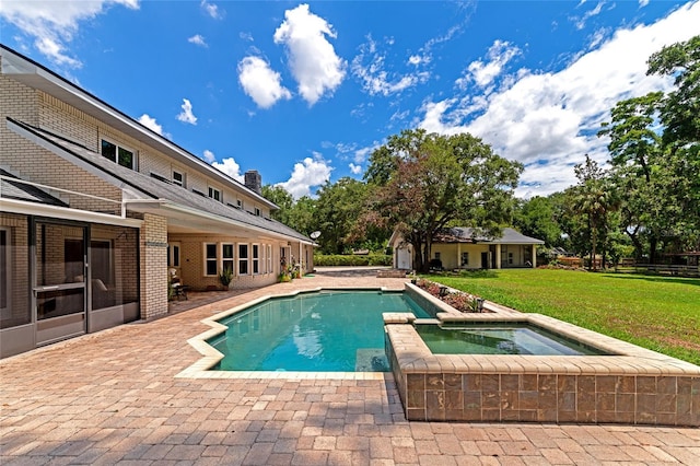 view of swimming pool with a lawn, an outbuilding, and an in ground hot tub