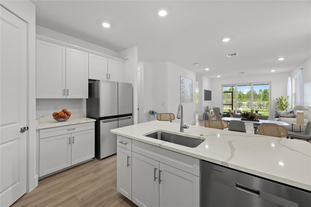 kitchen featuring white cabinets, light hardwood / wood-style flooring, sink, and stainless steel appliances