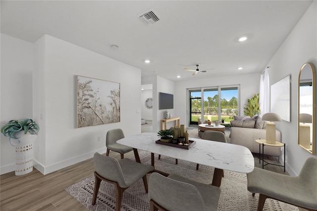 dining area with ceiling fan and light hardwood / wood-style flooring