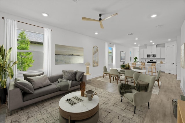 living room featuring ceiling fan and light hardwood / wood-style flooring