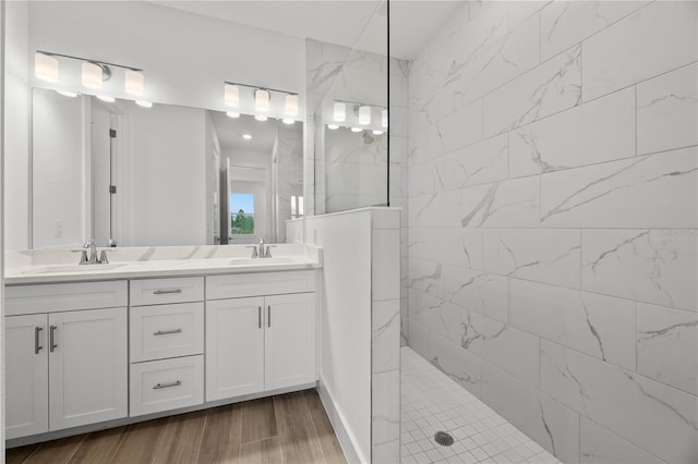 bathroom featuring tiled shower, wood-type flooring, and vanity