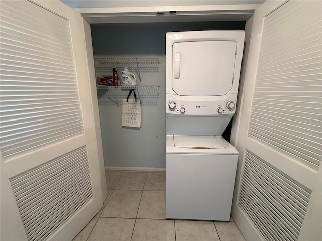 clothes washing area with stacked washer and dryer and light tile patterned floors