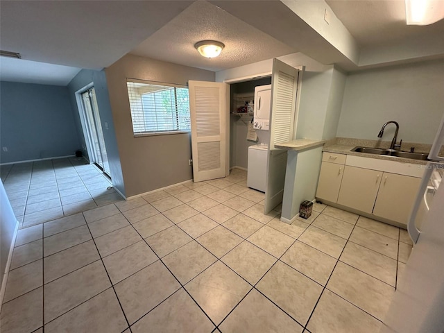 kitchen featuring sink, light tile patterned floors, and a textured ceiling