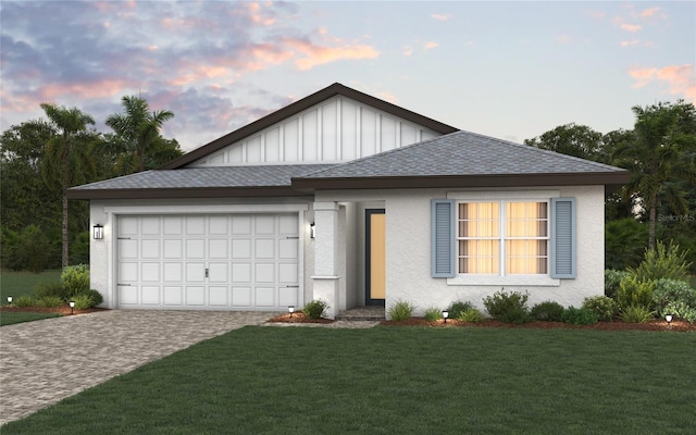 view of front of property featuring a garage and a lawn