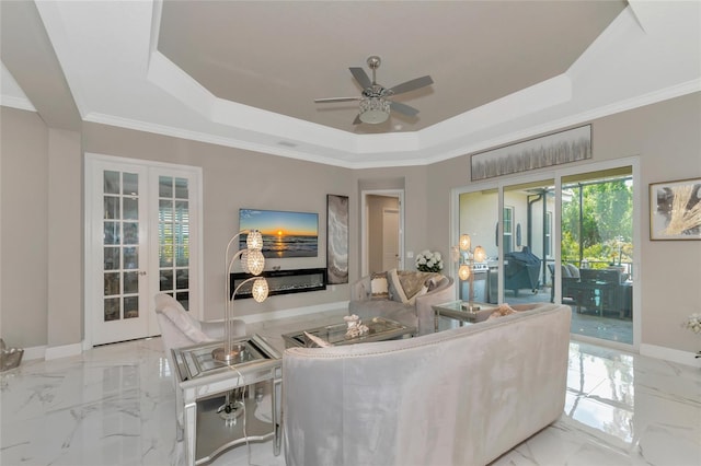 living room with french doors, crown molding, and a tray ceiling