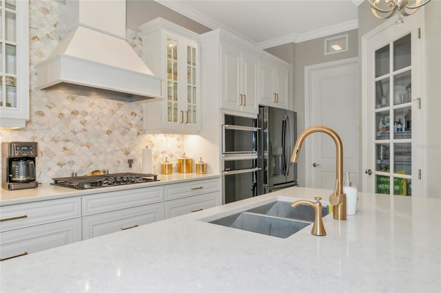 kitchen with tasteful backsplash, custom range hood, stainless steel appliances, crown molding, and white cabinetry