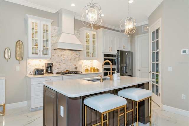 kitchen with premium range hood, a center island with sink, decorative backsplash, white cabinetry, and stainless steel appliances