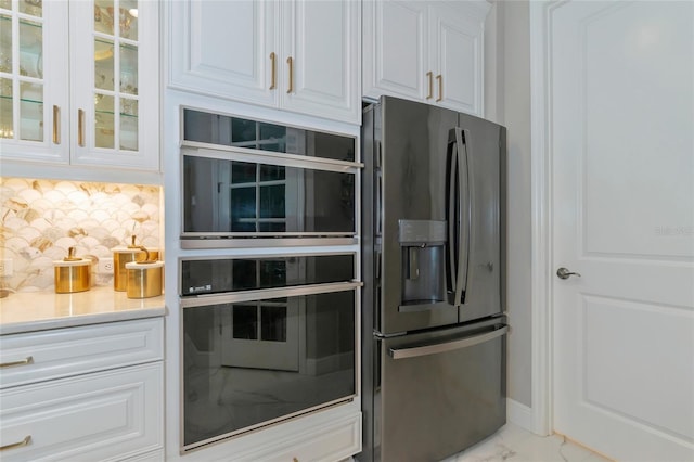 kitchen with stainless steel fridge, backsplash, double oven, beverage cooler, and white cabinetry