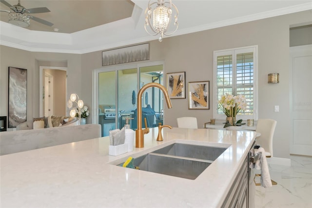 kitchen with ceiling fan with notable chandelier, crown molding, and sink