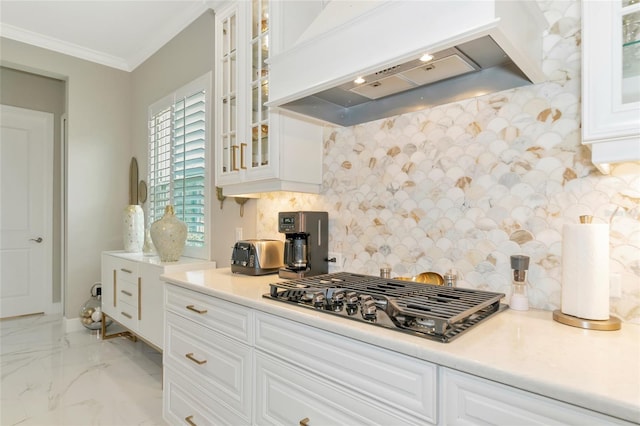 kitchen featuring white cabinets, decorative backsplash, custom range hood, and stainless steel gas stovetop