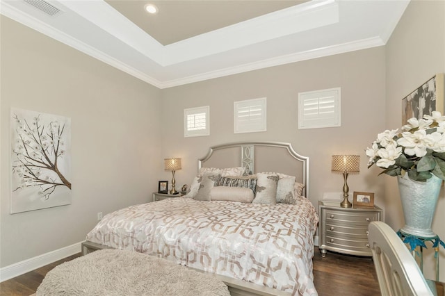 bedroom with dark hardwood / wood-style flooring, a raised ceiling, and ornamental molding