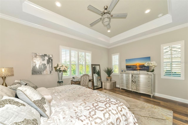 bedroom featuring hardwood / wood-style flooring, a raised ceiling, ceiling fan, and crown molding