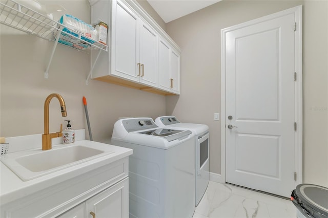 laundry area with cabinets, washer and clothes dryer, and sink