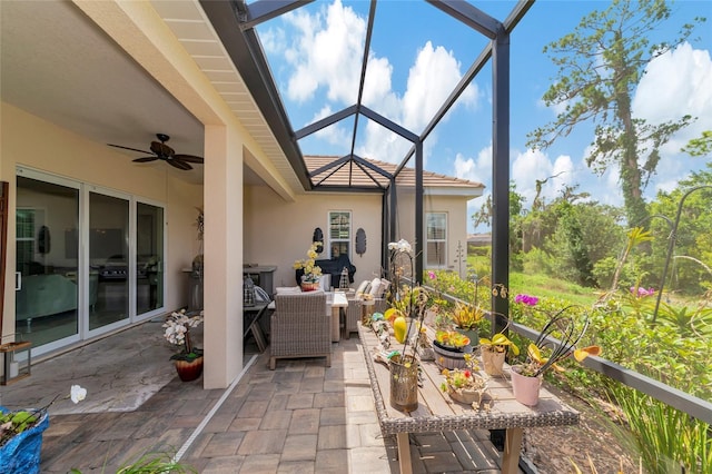 view of patio with glass enclosure, ceiling fan, and an outdoor hangout area