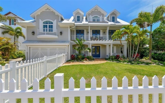 view of front of house featuring a front lawn, a balcony, and a garage