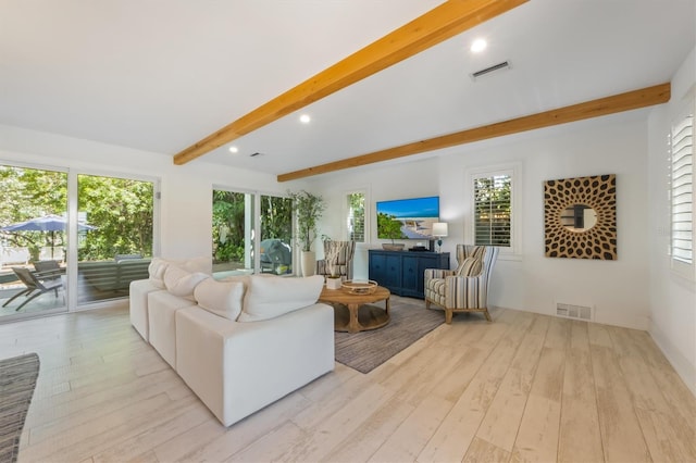 living room featuring beamed ceiling and light hardwood / wood-style floors