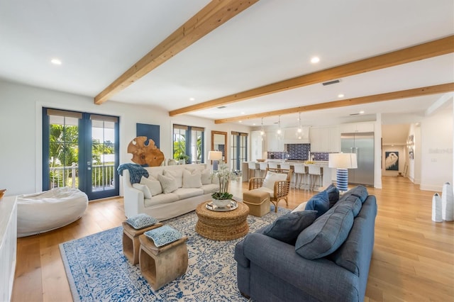 living room with beamed ceiling, french doors, and light hardwood / wood-style floors