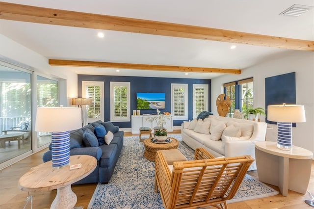 living room featuring beamed ceiling and light hardwood / wood-style floors