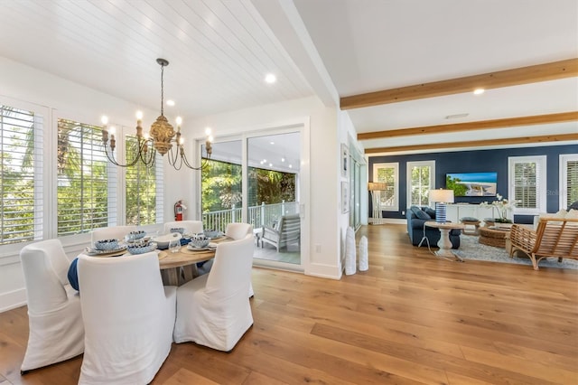 dining space featuring light hardwood / wood-style flooring, an inviting chandelier, and a healthy amount of sunlight