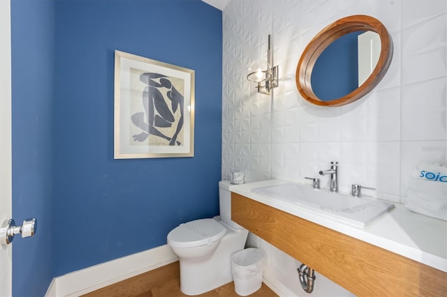 bathroom featuring hardwood / wood-style floors, backsplash, vanity, and toilet