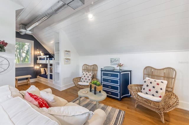 living room featuring hardwood / wood-style floors, built in shelves, and vaulted ceiling