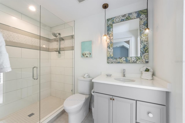 bathroom with toilet, tile patterned floors, vanity, and a shower with shower door