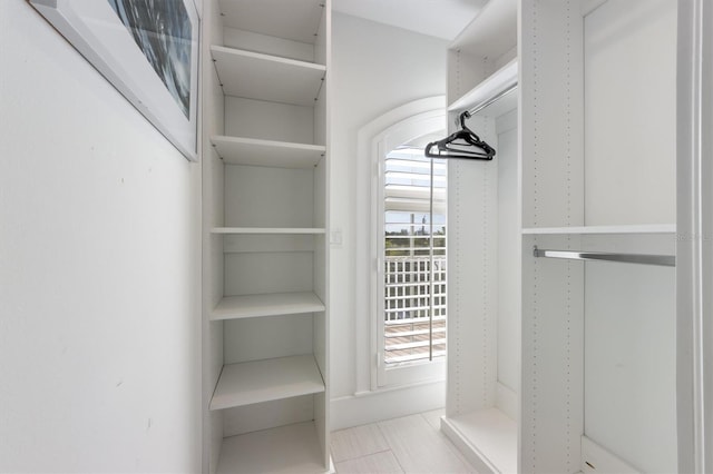 walk in closet with light tile patterned floors