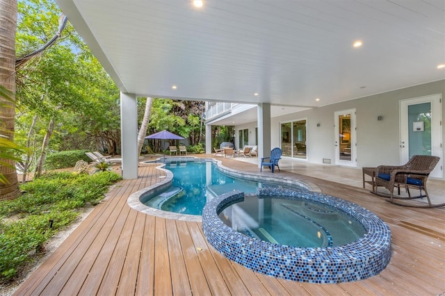 view of pool featuring an in ground hot tub, a patio area, and a deck