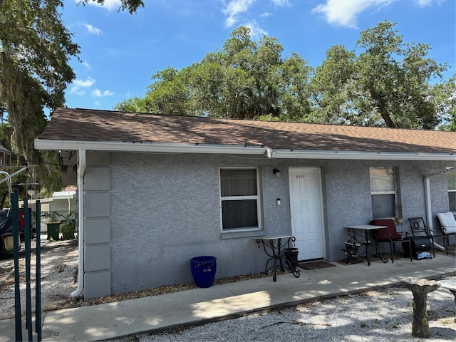 view of front of home featuring a shingled roof and stucco siding