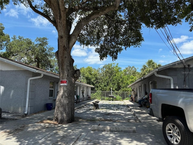 view of side of property with fence and stucco siding