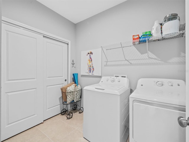 washroom featuring washing machine and dryer and light tile floors