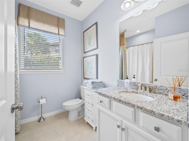 bathroom with tile flooring, toilet, and vanity