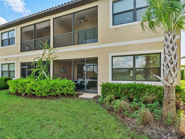 back of house with a balcony and a yard