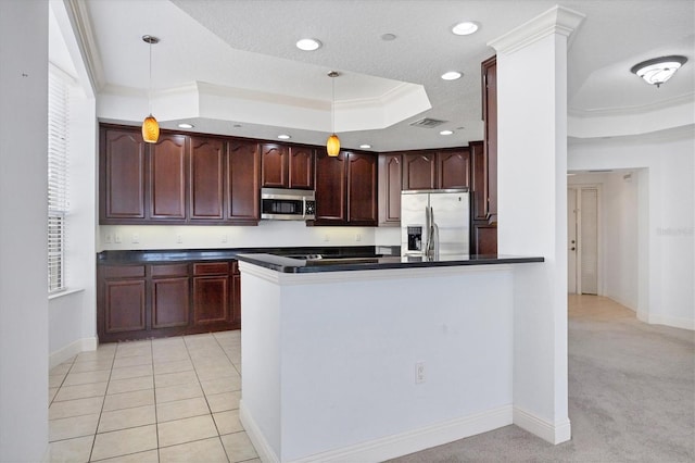 kitchen with a raised ceiling, crown molding, hanging light fixtures, and appliances with stainless steel finishes