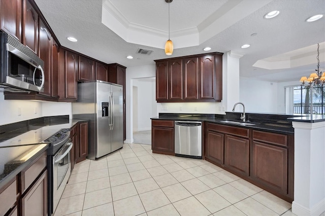 kitchen featuring a chandelier, stainless steel appliances, a raised ceiling, and crown molding