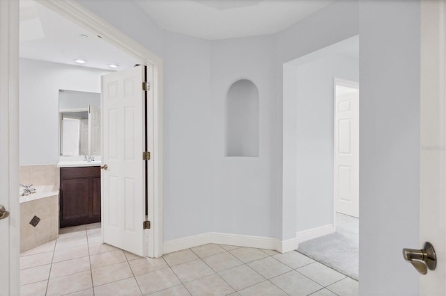 unfurnished room with light tile patterned floors and sink