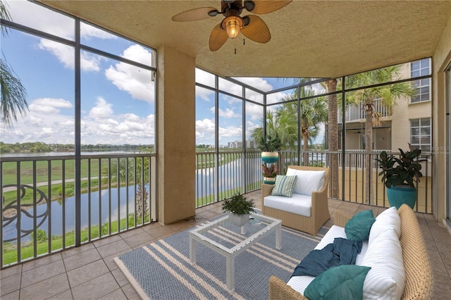 sunroom featuring a water view and ceiling fan