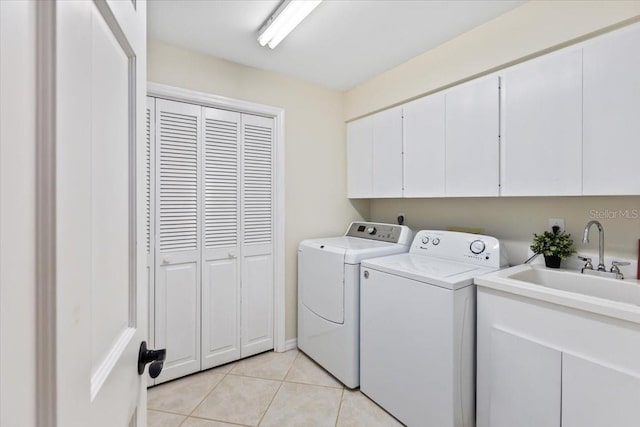 laundry area with separate washer and dryer, light tile patterned floors, sink, and cabinets