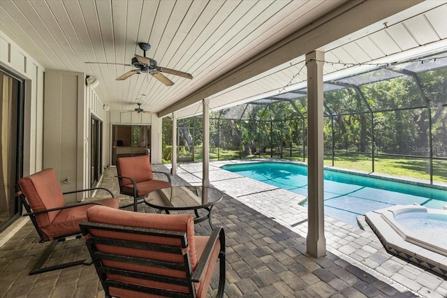 view of swimming pool featuring a patio area, a lanai, outdoor lounge area, an in ground hot tub, and ceiling fan